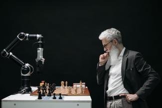 Elderly Man playing chess with a robot powered by AI