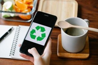 recycle logo in a persons handphone