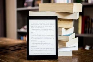 a tablet leaning on a stock of books